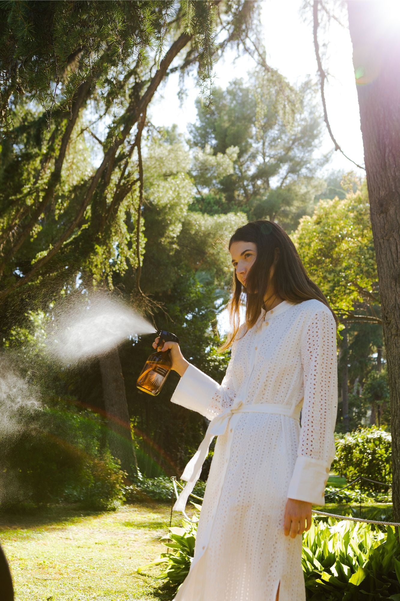 girl spraying natural cleaning products using a 500ml amber glass bottle