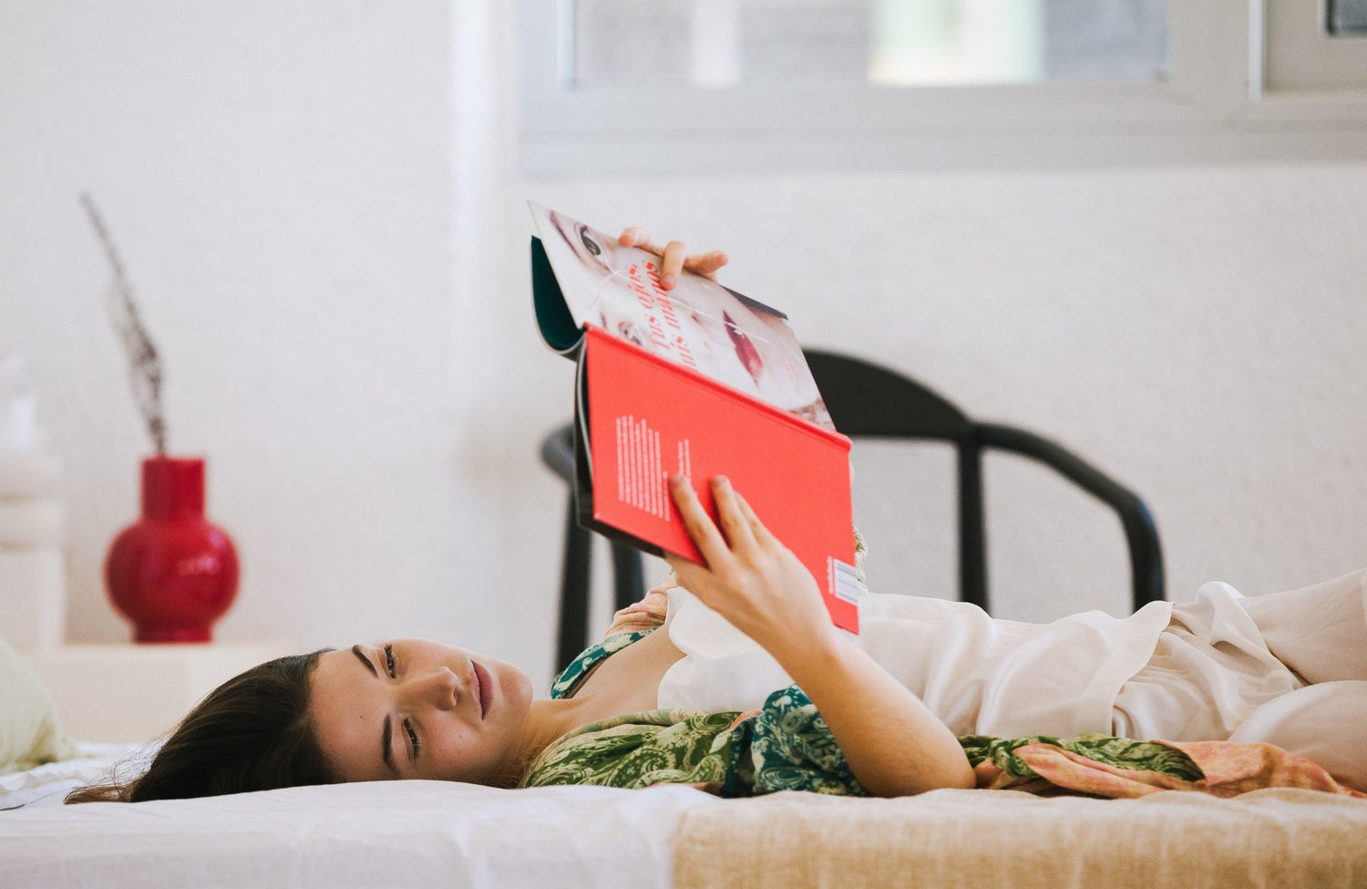 Girl reading book on bed while relaxing 